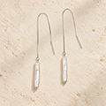 Moon Letter white pearl threader earrings on warm ivory stone