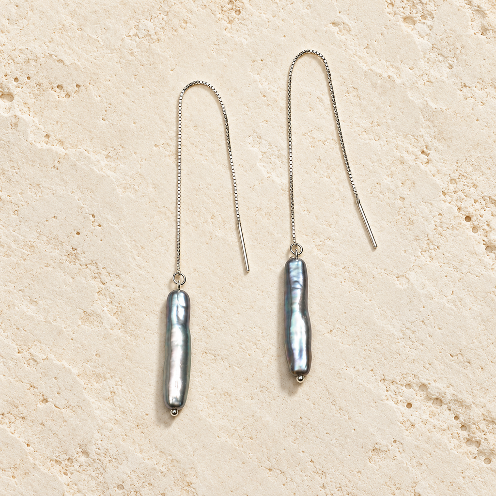Smoky Veil gray pearl threader earrings on warm ivory stone