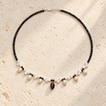 Midnight Ripple pearl tourmaline and tiger eye necklace on warm ivory stone